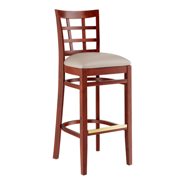 A Lancaster Table & Seating mahogany wood bar stool with a light gray cushioned seat.