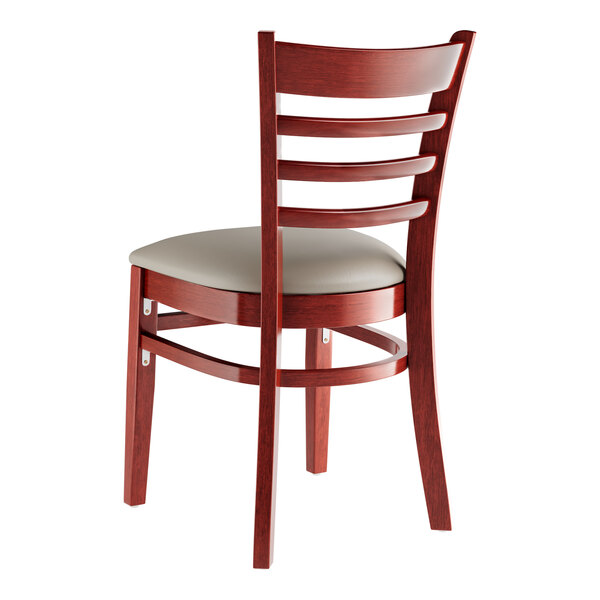 A Lancaster Table & Seating mahogany wood restaurant chair with a dark gray vinyl seat and ladder back.