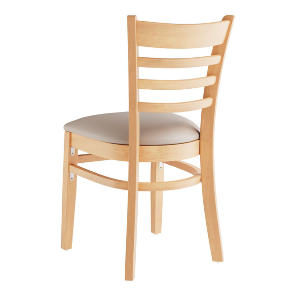 A Lancaster Table & Seating wooden ladder back chair with a light gray cushion.