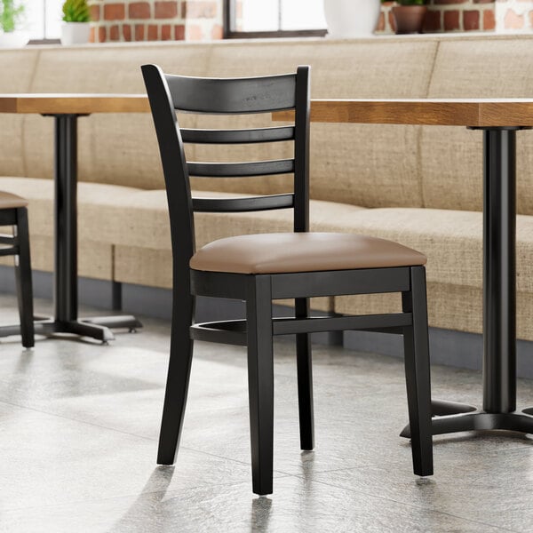 A Lancaster Table & Seating wood ladder back chair with a taupe vinyl seat detached from the chair.