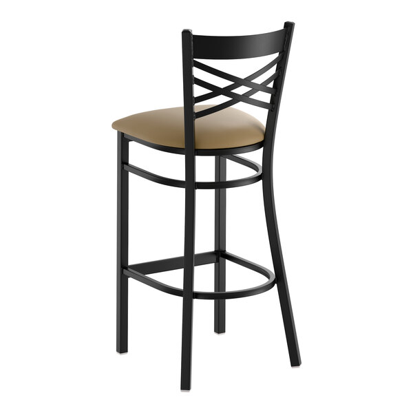 A black metal bar stool with a cross back design and a taupe vinyl padded seat.