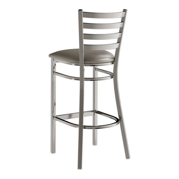 A metal bar stool with a ladder back design and a dark gray vinyl padded seat.