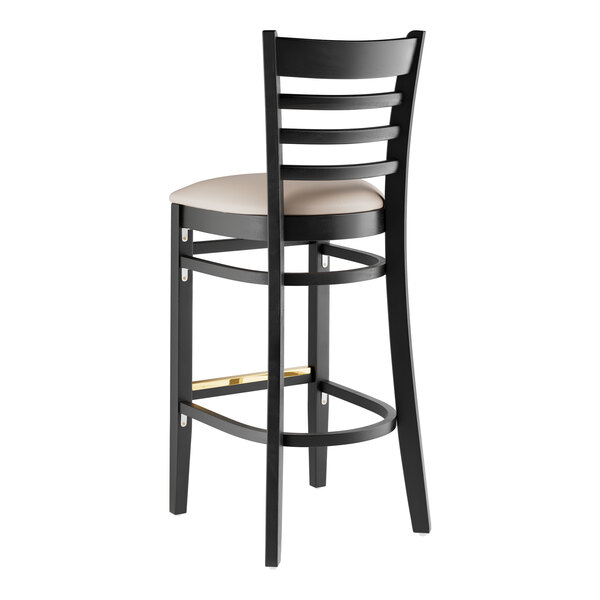 A black wood bar stool with a light gray cushion.