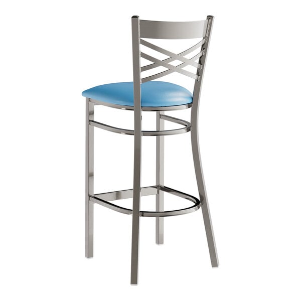 A Lancaster Table & Seating clear coated metal cross back bar stool with a detached blue vinyl padded seat.