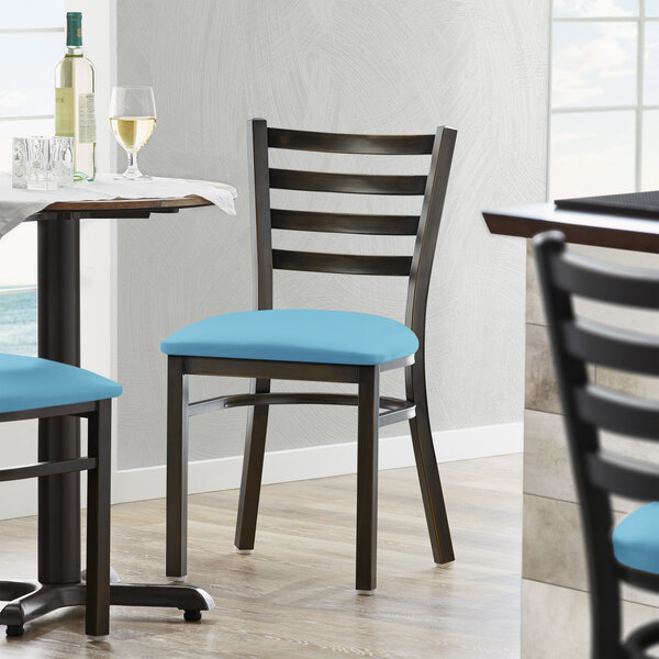 A Lancaster Table & Seating distressed copper ladder back chair with a blue vinyl padded seat.