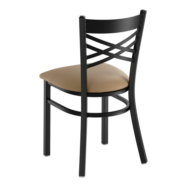 A black metal chair with a cross back design and a taupe vinyl padded seat.
