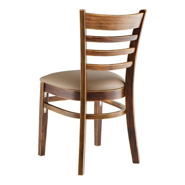 A Lancaster Table & Seating wood ladder back chair with a taupe vinyl seat.