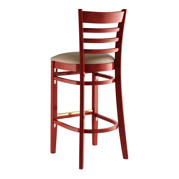 A Lancaster Table & Seating mahogany wood bar stool with a taupe cushioned seat.