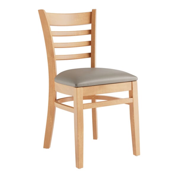 A Lancaster Table & Seating wooden chair with a dark gray vinyl cushion.