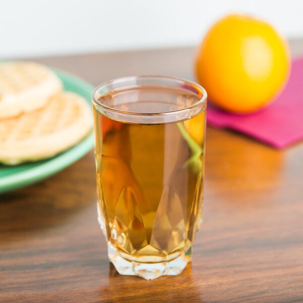 A glass of orange juice on a table.