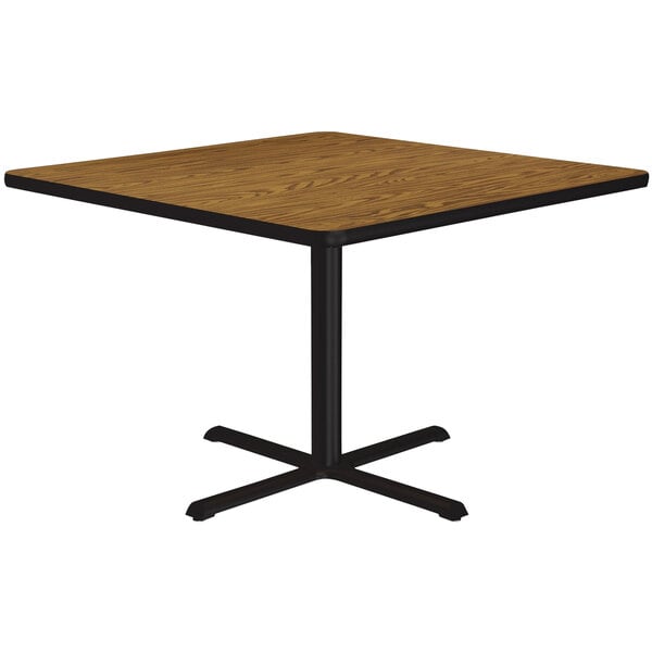 A Correll square table with a black base and a wooden top.