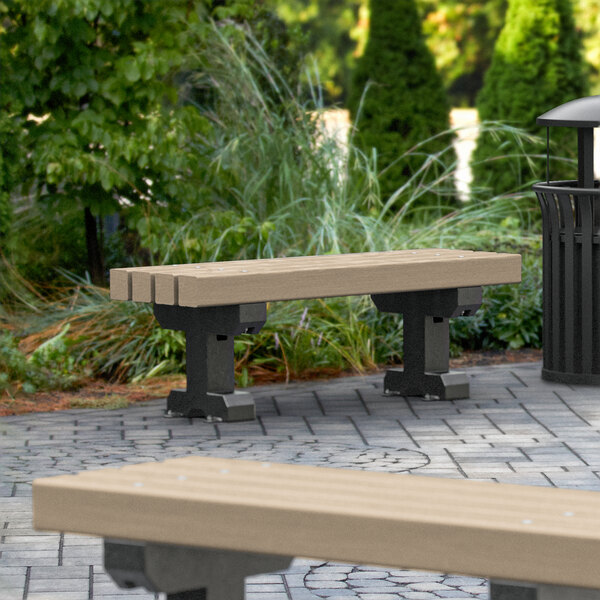 A MasonWays backless Dura-Bench with black legs and a trash can in a park.