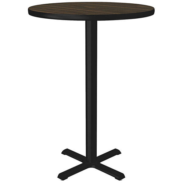 A Correll round walnut bar height table with a black metal base.