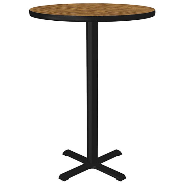 A Correll round bar height table with a medium oak thermal-fused laminate top and black base.