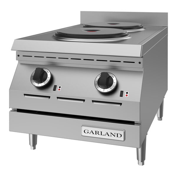A stainless steel countertop hot plate with two solid electric burners and control knobs.