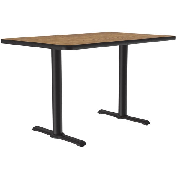 A Correll rectangular table with a medium oak top and two black T bases.