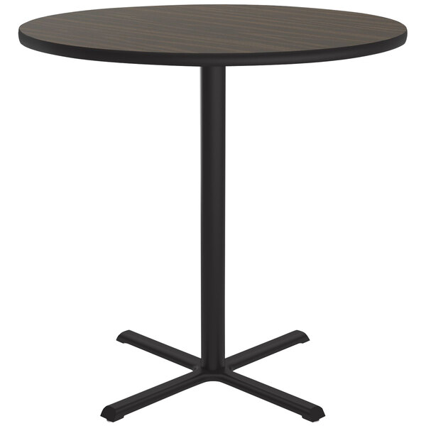 A Correll round bar height table with a walnut finish wood top and black base.