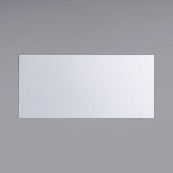 A white rectangular sign panel with a black border on a gray surface.