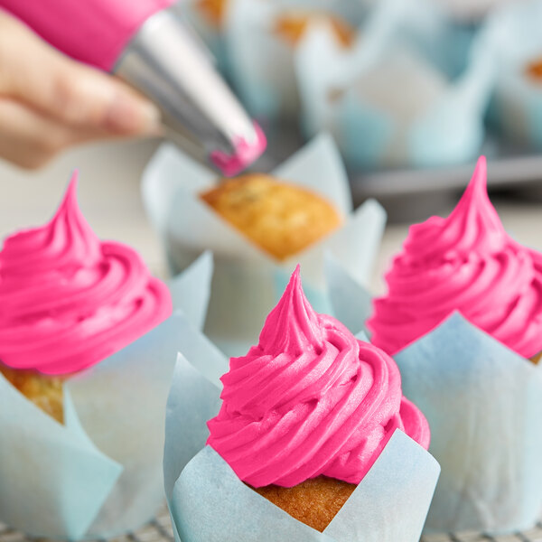 A cupcake with Rich's Allen Bright Pink Buttrcreme icing.