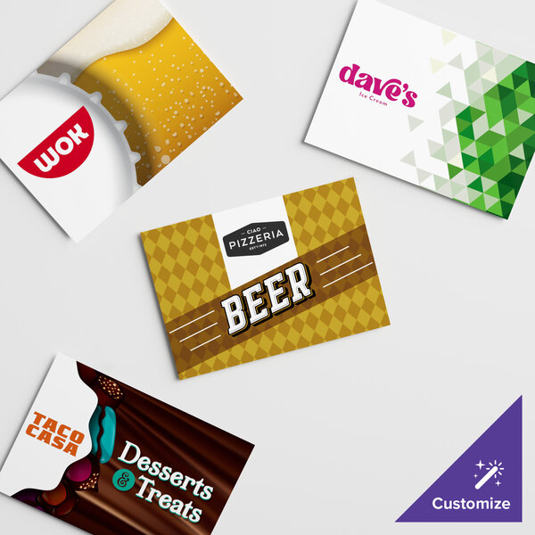 A white and green card with pink text, a yellow and white label, and a group of business cards with a chocolate bar wrapper.