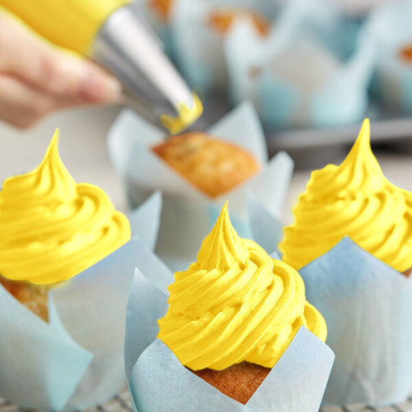 A cupcake with Rich's Allen Pastel Yellow Buttrcreme icing in a yellow swirl.