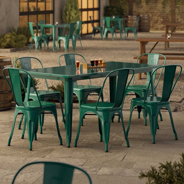 A Lancaster Table & Seating emerald green table with chairs on an outdoor patio.