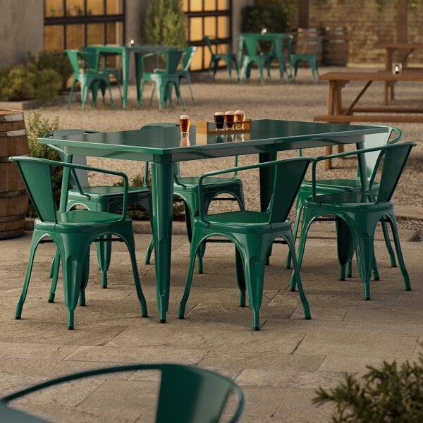 A Lancaster Table & Seating emerald green table with 6 green chairs on a patio.