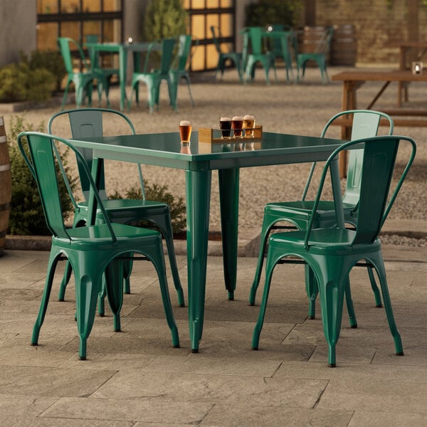 An emerald green Lancaster Table & Seating outdoor table with four chairs.