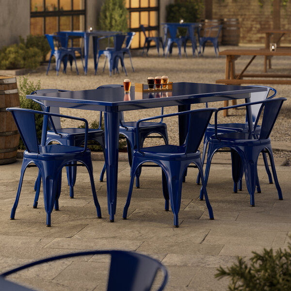 A blue metal Lancaster Table & Seating outdoor table with chairs.