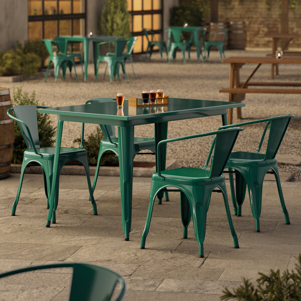 An emerald green Lancaster Table & Seating outdoor table with four chairs.