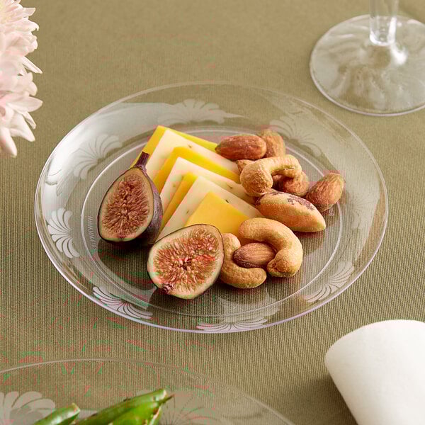 A WNA Comet clear plastic plate with cheese and nuts on it.