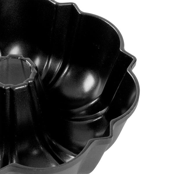 A close-up of a black Chicago Metallic fluted Bundt cake pan.