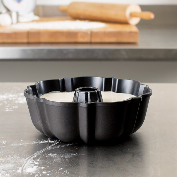 A Chicago Metallic fluted bundt cake pan on a counter with white substance in it.