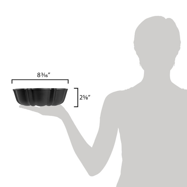 A woman holding a black Chicago Metallic fluted bundt cake pan.