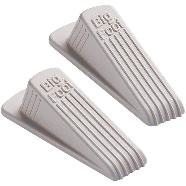 A close-up of a pair of beige rubber Master Caster door stops.