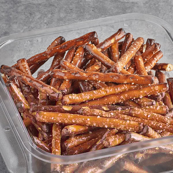 A container of Tom Sturgis Thick Stiks pretzels with sesame seeds.
