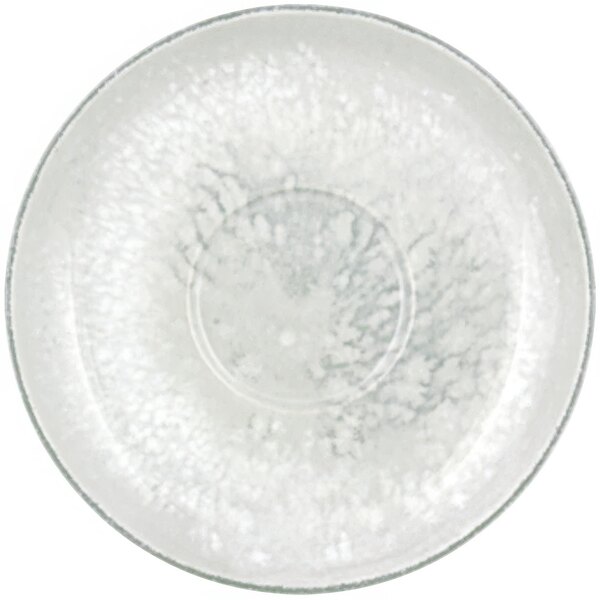 A white porcelain saucer with a circular design on the rim.