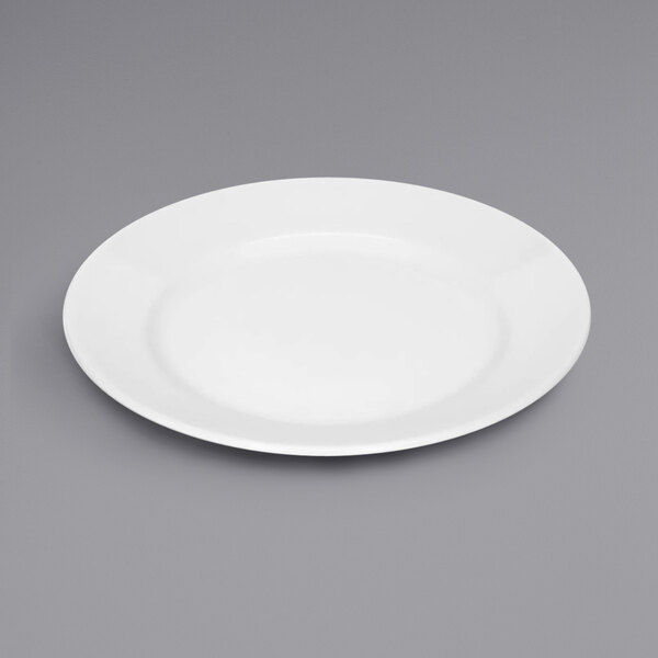 A Bauscher bright white porcelain plate with a wide rim on a gray surface.