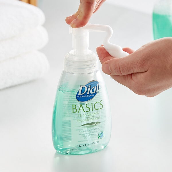 A hand using a Dial Professional Basics foaming soap pump.