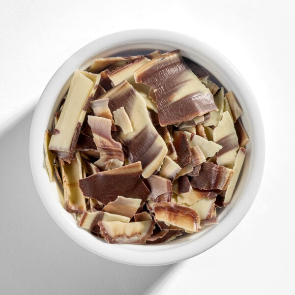 A bowl of marbled chocolate shavings with a mix of light and dark chocolate colors.