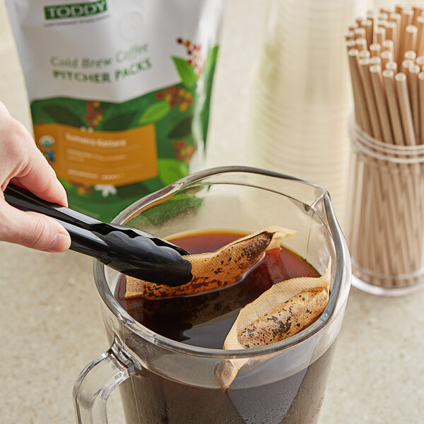 A person pouring Toddy cold brew coffee from a bag into a glass.