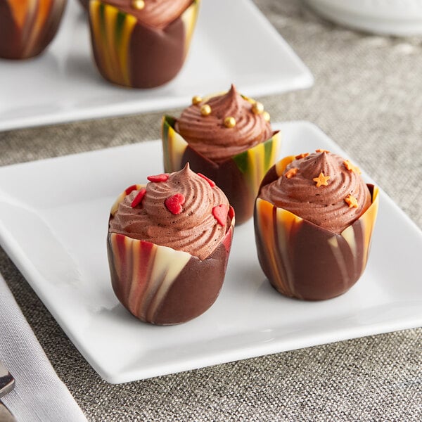 A marbled chocolate tulip cup filled with chocolate on a plate.
