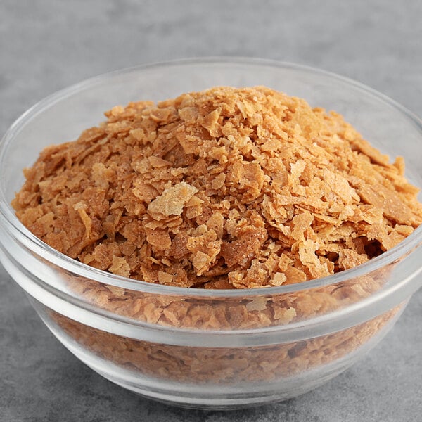 A bowl of Cacao Barry Feuilletine flakes on a table.