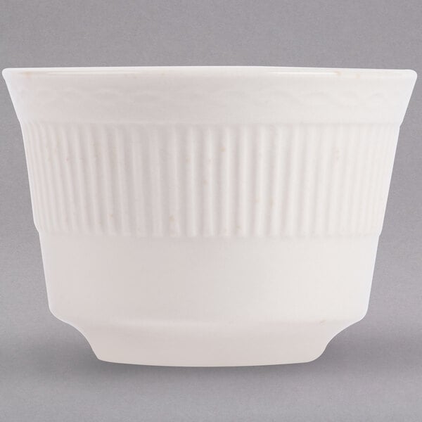 An ivory bouillon cup with an embossed rim.