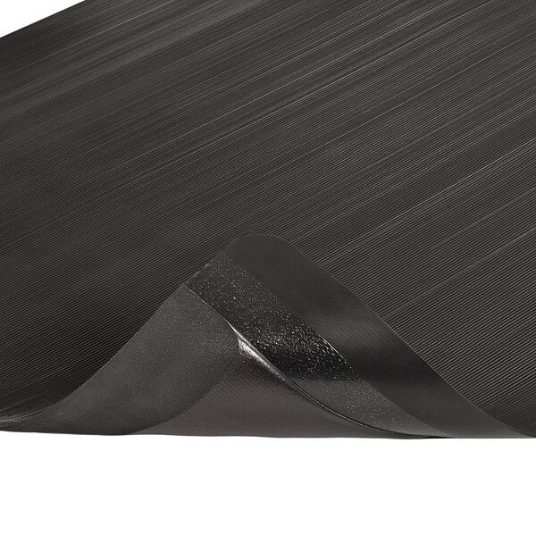 A close-up of a black Notrax anti-fatigue mat with a black rubber edge.