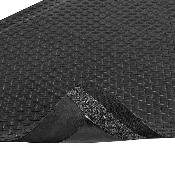 A black rubber Notrax Diamond-Tuff mat with a corner cut off.