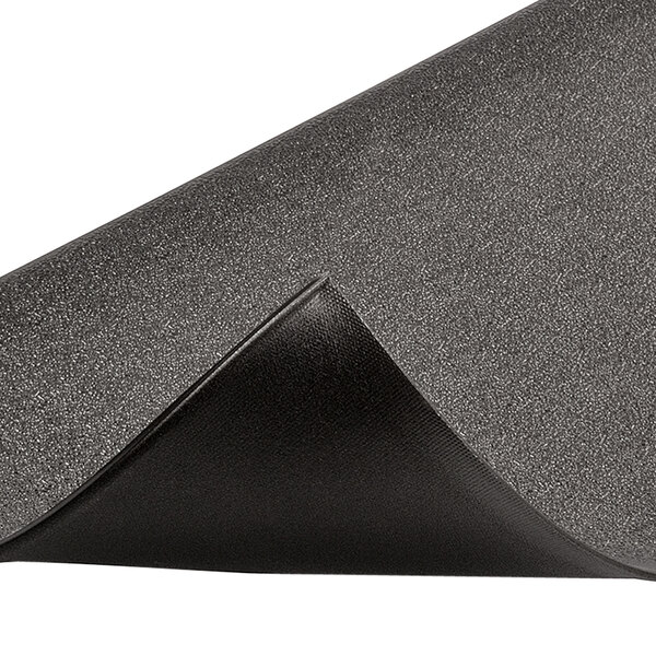 A close up of a Notrax black rubber mat with a curved corner and a folded edge.