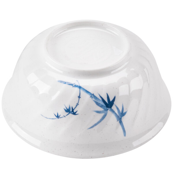 A white bowl with blue and white painted bamboo designs.
