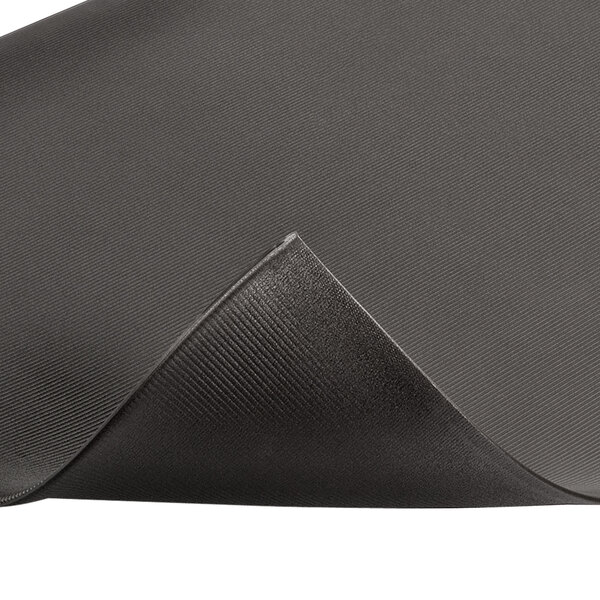 A black rubber mat with a folded edge and a curved corner.