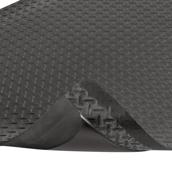 A black rubber Notrax Dura Trax Grande anti-fatigue mat with a corner curled up.